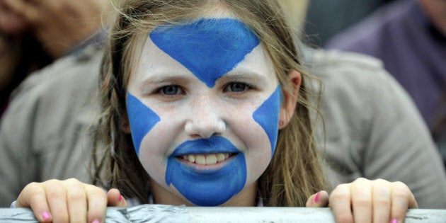 A child with her face painted with the Scottish flag looks on as pro-independence supporters gather for a rally in Edinburgh on September 21, 2013. Voting for Scottish independence is 'common sense', the leader of the movement to break away from the United Kingdom insisted a year to the day befor Scotland votes in a referendum. AFP PHOTO/ANDY BUCHANAN (Photo credit should read Andy Buchanan/AFP/Getty Images)