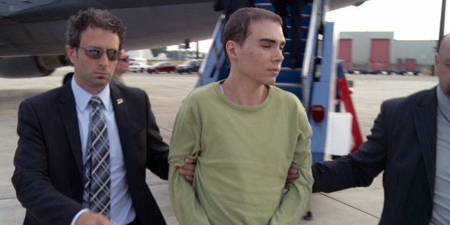 In this photo provided by Montreal Police, Luka Rocco Magnotta is taken by police from a Canadian military plane to a waiting van on Monday, June 18, 2012, in Mirabel, Quebec. Magnotta, the suspect in the killing and dismemberment of a Chinese student, returned to Canada via military transport from Germany, where he was arrested this month. (AP Photo/Montreal Police)