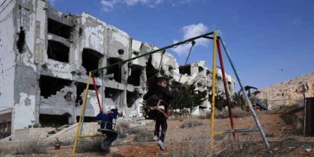 Children play on a swing in the park of the Safir Maalula Hotel, in the ancient Christian town of Maalula, 56 kilometers northeast of the Syrian capital Damascus, on December 20, 2014. AFP PHOTO / YOUSSEF KARWASHAN (Photo credit should read YOUSSEF KARWASHAN/AFP/Getty Images)