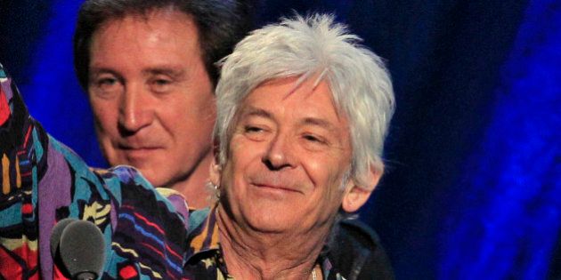 Ian McLagan, right, holds up his trophy after he and Ron Wood, left, and Kenney Jones, background, were inducted into the Rock and Roll Hall of Fame as members of the Small Faces/Faces Saturday, April 14, 2012, in Cleveland. (AP Photo/Tony Dejak)
