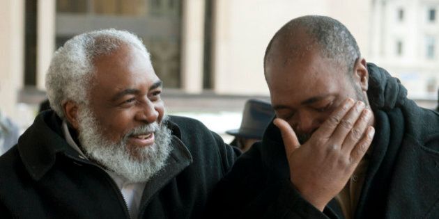 Wiley Bridgeman, 60, of Cleveland, left, is all smiles as his brother, Ronnie who is now known as Kwame Ajamu chokes up as they walk from the Cuyahoga County Justice Center, after Bridgeman's release from a life sentence for a 1975 murder, Friday, Nov. 21, 2014, in Cleveland. The dismissal came after the key witness against Bridgeman, his brother and childhood friend Ricky Jackson recanted last year and said Cleveland police detectives coerced him into testifying that the three killed businessman Harry Franks the afternoon of May 19, 1975. (AP Photo/Phil Long)