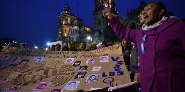 People demonstrate against the presumed massacre of 43 students, in Mexico City, on November 20, 2014. Tens of thousands of people angry at the presumed massacre of 43 students marched in Mexico City on Thursday, many chanting for President Enrique Pena Nieto's resignation in another day of nationwide protests. It is the latest protest over the government's handling of a crime that has infuriated Mexicans fed up with corruption, impunity and a drug war that has left more than 100,000 people dead or missing since 2006. AFP PHOTO/YURI CORTEZ (Photo credit should read YURI CORTEZ/AFP/Getty Images)