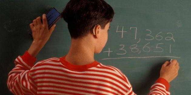 Hearing Impaired boy writing a math equation on a chalkboard (Photo by: Digital Light Source/UIG via Getty Images)