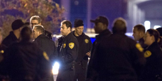 Tallahassee police chief Michael Deleo, center, talks with his officers as they investigate a shooting outside the Strozier library on the Florida State University campus in Tallahassee, Fla. Nov 20, 2014. The gunman was shot and killed by police officers according to Tallahassee Police spokesman Dave Northway. (AP Photo/Mark Wallheiser)