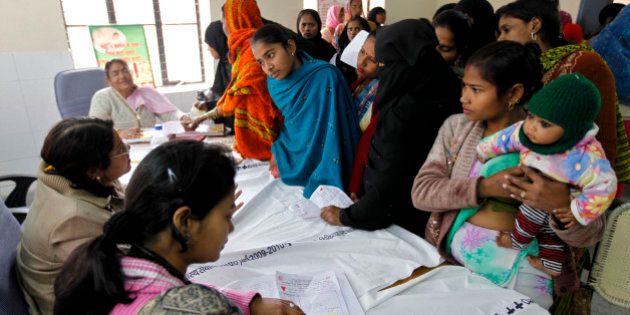 In this Feb. 4, 2011 photo, patients get registered for a free sterilization procedure at the Mohan Lal Gautam District Women's Hospital in Aligarh, India. Every day dozens of women line up at this hospital for a free sterilization procedure that will spare them the risk and cost of having another child. The hospital's three staff doctors race through seeing some 500 patients a day needing help with childbirth, pelvic inflammatory diseases, abortions and other treatments at subsidized costs. Each year, the cost of health care pushes some 39 million people into poverty, with patients shouldering up to 80 percent of India's medical costs. (AP Photo/Mustafa Quraishi)