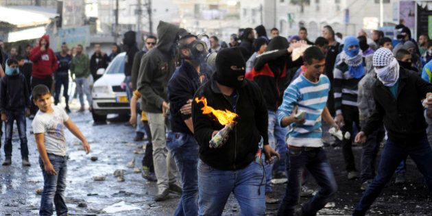 A Palestinian holds a molotov cocktail during clashes with Israeli border police, as Israeli police limited the access to Al-Aqsa Mosque in Jerusalem on Friday, Nov. 7, 2014. Tensions have been rising in recent weeks over the Jerusalem shrine, known to Muslims as Haram al-Sharif, or Noble Sanctuary, and to Jews as the Temple Mount. (AP Photo/Mahmoud Illean)