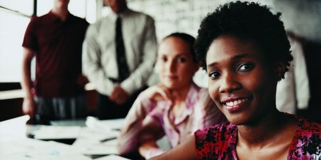 Portrait of a Fashion Designer Sitting in Front of Three of Her Colleagues at a Desk