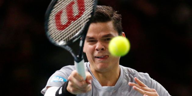 Milos Raonic of Canada returns the ball to Roger Federer of Switzerland during their quarterfinal match at the ATP World Tour Masters tennis tournament at Bercy stadium in Paris, France, Friday, Oct. 31, 2014. Raonic won 7-6, 7-5. (AP Photo/Michel Euler)