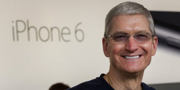 Tim Cook, chief executive officer of Apple Inc., stands for a photograph during the sales launch for the iPhone 6 and iPhone 6 Plus at the Apple Inc. store in Palo Alto, California, U.S., on Friday, Sept. 19, 2014. Apple Inc.'s stores attracted long lines of shoppers for the debut of the latest iPhones, indicating healthy demand for the bigger-screen smartphones. The larger iPhone 6 Plus is already selling out at some stores across the U.S. Photographer: David Paul Morris/Bloomberg via Getty Images