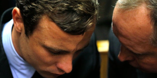 PRETORIA, SOUTH AFRICA - AUGUST 19: South African athlete Oscar Pistorius (L) speaks with his lawyer Kenny Oldwage in Pretoria Magistrates Court prior to an indictment hearing on August 19, 2013 in Pretoria, South Africa. Pistorius, 26 is accused of murdering his girlfriend Reeva Steenkamp which Pistorius denies claiming he mistook Steenkamp for an intruder. The indictment was served and the trial date of March 3, 2014 has now been set. (Photo by Jemal Countess/Getty Images)