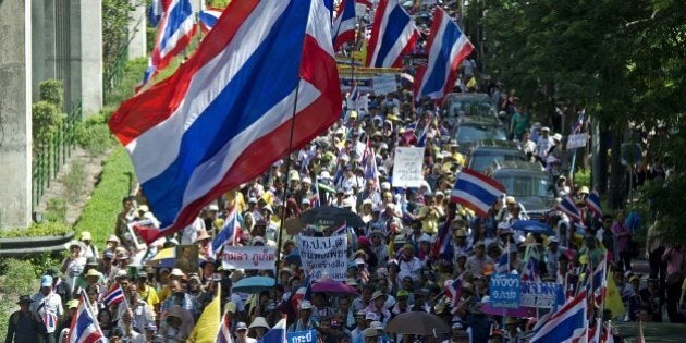 Thai anti-government protesters wave national flags during a rally in Bangkok on May 12, 2014. Thailand's authorities warned on May 11 that opposition efforts to hand power to an unelected regime risked unleashing new violence, as rival protesters prepared for a showdown over the fate of the crippled government. AFP PHOTO / PORNCHAI KITTIWONGSAKUL (Photo credit should read PORNCHAI KITTIWONGSAKUL/AFP/Getty Images)