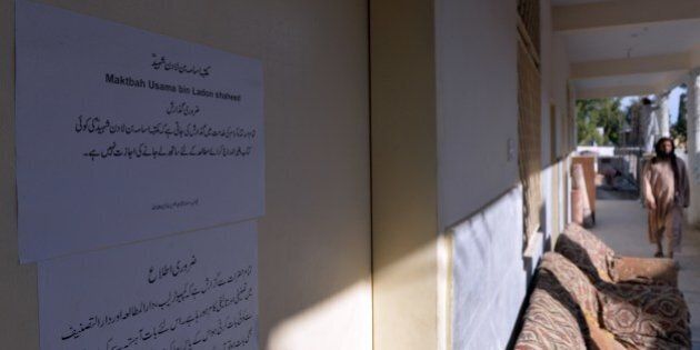 A Pakistani Islamic student walks past a door of a library named after slain Al-Qaeda leader Osama bin Laden at a Jamia Hafsa seminary in Islamabad on April 17, 2014. A religious school for women in the Pakistani capital Islamabad has renamed its library in honour of slain Al-Qaeda leader Osama bin Laden. The seminary is run by controversial hardline cleric Maulana Abdul Aziz, the imam of the city's Red Mosque, once notorious as a hideout for hardliners with alleged militant links. AFP PHOTO/Aamir QURESHI (Photo credit should read AAMIR QURESHI/AFP/Getty Images)