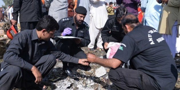 Pakistani security officials collect evidence at the site of a bomb explosion in a fruit and vegetable market in Islamabad on April 9, 2014. A bomb explosion killed at least 22 people and wounded 50 others in Islamabad's bustling fruit and vegetable market, police and hospital officials said. AFP PHOTO/Aamir QURESHI (Photo credit should read AAMIR QURESHI/AFP/Getty Images)