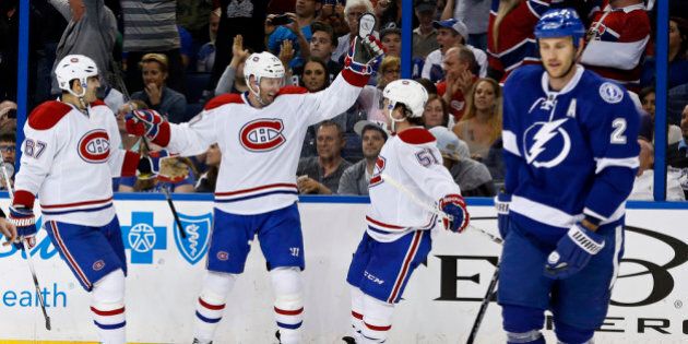 TAMPA, FL - APRIL 16: Thomas Vanek #20 of the Montreal Canadiens (C) celebrates his goal with teammates \Max Pacioretty #67 and David Desharnais #51 as Eric Brewer #2 of the Tampa Bay Lightning reacts in Game One of the First Round of the 2014 Stanley Cup Playoffs at the Tampa Bay Times Forum on April 16, 2014 in Tampa, Florida. (Photo by Mike Carlson/Getty Images)