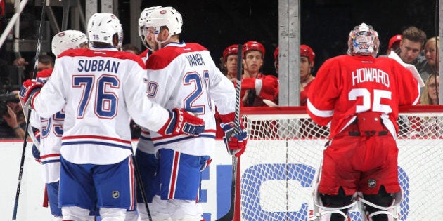 DETROIT, MI - MARCH 27: Jimmy Howard #35 of the Detroit Red Wings grabs his water bottle as P.K. Subban #76, Francis Bouillon #55, Thomas Vanek #20 and Max Pacioretty #67 of the Montreal Canadiens congratulate teammate David Desharnais #51 after scoring a goal during an NHL game on March 27, 2014 at Joe Louis Arena in Detroit, Michigan. (Photo by Dave Reginek/NHLI via Getty Images)