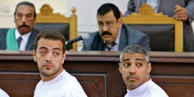 Cameraman Baher Mohamed, left, and Mohamed Fadel Fahmy, the Cairo bureau chief for al Jazeera English, look at reporters sitting behind them Monday, March 31, 2014, as Judge Mohamed Nagy listens to the defendants' complaints about the conditions they are being held in. Three Al Jazeera journalists, including Australian Peter Greste (not pictured) are standing trial on terror charges. (Amina Ismail/MCT via Getty Images)