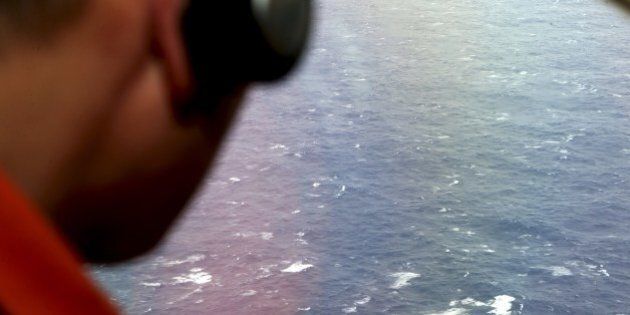Kazuhiko Morisawa looks out of a window of a Japan Coast Guard Gulfstream aircraft during the search for wreckage and debris of missing Malaysia Airlines Flight MH370 in the Southern Indian Ocean on April 1, 2014. Malaysia revealed the full radio communications with the pilots of its missing flight on April 1, but the routine exchanges shed no light on the mystery as an Indian Ocean search for wreckage bore on with no end in sight. AFP PHOTO / POOL / Rob GRIFFITH (Photo credit should read ROB GRIFFITH/AFP/Getty Images)
