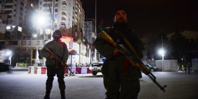 Afghan policemen block a road as they stands guard near the security perimeter setup around the Serena hotel in Kabul early on March 21, 2014. Security forces rushed to the luxury Serena hotel in central Kabul on March 20 evening after gunshots were heard at the venue, a high-security location favoured by foreign visitors to the Afghan capital. The gunfire at the hotel came on the same day that seven Taliban suicide attackers stormed a police station in the eastern city of Jalalabad killing 10 policemen. AFP PHOTO / SHAH MARAI (Photo credit should read SHAH MARAI/AFP/Getty Images)