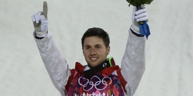 Gold Medallist, Canada's Alex Bilodeau celebrates on the podium at the Men's Freestyle Skiing Moguls Flower Ceremony at the Rosa Khutor Extreme Park during the Sochi Winter Olympics on February 10, 2014. AFP PHOTO / FRANCK FIFE (Photo credit should read FRANCK FIFE/AFP/Getty Images)