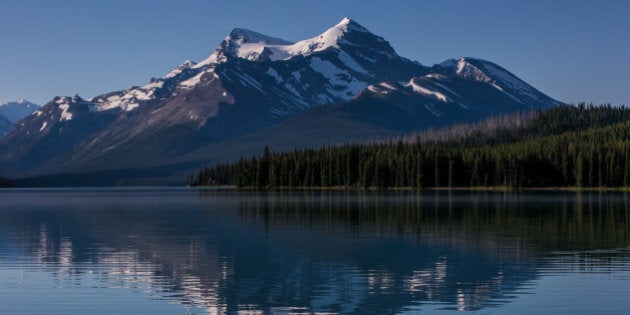 JASPER, CANADA - JUNE 30: The surrounding snowcapped mountains are reflected in Maligne Lake on June 30, 2013 near Jasper, Alberta, Canada. Jasper is the largest National Park in the Canadian Rockies and features glaciers, hot springs, lakes, waterfalls, and mountains. (Photo by George Rose/Getty Images)