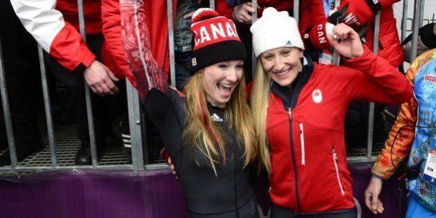 Gold Medallist, Canada-1 two-woman bobsleigh pilot Kaillie Humphries (R bottom) and brakewoman Heather Moyse celebrate with family and friends after the Women's Bobsleigh Heat 4 and final run at the Sliding Center Sanki during the Sochi Winter Olympics on February 19, 2014. (Photo credit should read JOHN MACDOUGALL/AFP/Getty Images)