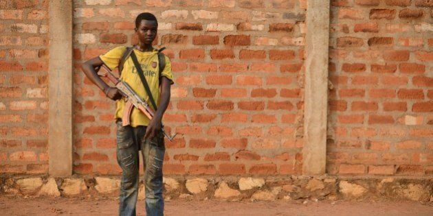 A young anti-Balaka combattant stands guard in a street of the Cattin district of Bangui, on January 18, 2014, two days before the election of the next interim president of Centrafrica. Fresh fighting broke out in the strife-torn Central African Republic as the deadline closed today for candidates seeking to be chosen by parliament as the new interim president. AFP PHOTO / ERIC FEFERBERG (Photo credit should read ERIC FEFERBERG/AFP/Getty Images)