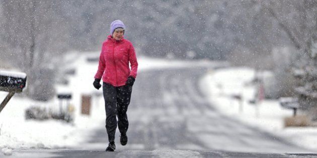 Sally Assmann runs through falling snow along Cambridge Drive in State College, Pa., Tuesday, Nov. 26, 2013. The first significant snowfall of the season fell overnight and continued through the morning. (Nabil K. Mark/Centre Daily Times/MCT via Getty Images)