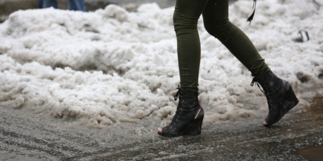 NEW YORK, NY - FEBRUARY 05: A woman with open toe boots navigates a slushy intersection near Union Square on February 5, 2014 in New York City, United States. New Yorkers, like millions of Americans in the northeast, dealt with the latest winter storm, which dumped 4 inches of snow on Central Park before turning to rain. (Photo by John Moore/Getty Images)