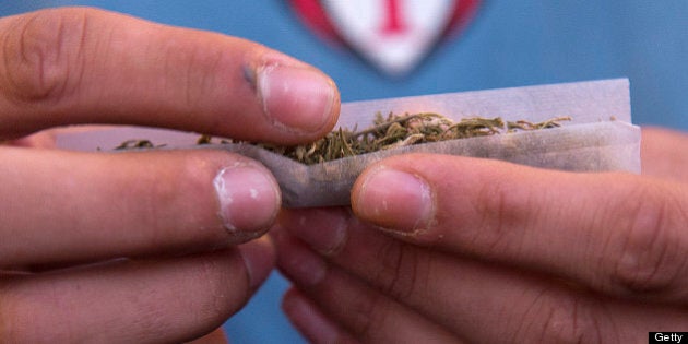 A young man rolls a marijuana joint during a demonstration demanding a new law on cannabis in Montevideo on May 8, 2013. Lawmakers in Uruguay are studying a bill to legalize the cultivation of marijuana and allow limited personal consumption of it -- which if passed, will have authorities controlling its quality and the amount used. With the bill, which is supported by President Jose Mujica, the government wants to end drug-related violent crime which in recent years has emerged for the first time in the South American nation. AFP PHOTO/Pablo PORCIUNCULA (Photo credit should read PABLO PORCIUNCULA/AFP/Getty Images)