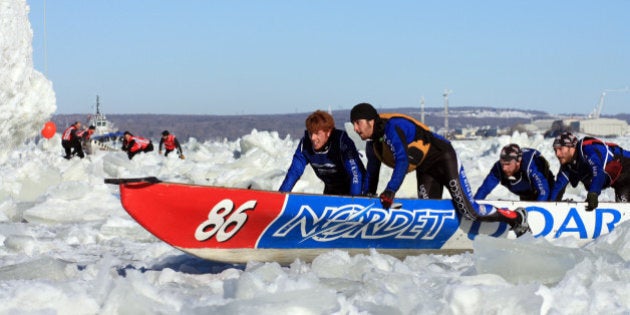 TO GO WITH AFP STORY CANADA-QUEBEC-SOCIETY-WINTERThe Université du Québec à Rimouski (UQAR) team engage in the canoe race on the St. Lawrence River in Quebec City, on February 10. Canoe Races, snow baths, sliding on tubes, dog sledding, hockey, table football human ... between sporting events, games and challenges crazy, everything is good to take against the winter-foot Carnaval de Québec. Accustomed to living with the cold, Quebecers do not hibernate and even profit from the winter freeze nature in a glossy décor to engage in activities a little crazy, they have invented to 'break the ice' .The 59th Quebec Winter Carnival, which makes the heart beat of the city of La Belle Province since the beginning of February is a perfect illustration of the ability to grow their warm and cheerful defogger. AFP PHOTO/FREDERIC BERG (Photo credit should read FREDERIC BERG/AFP/Getty Images)