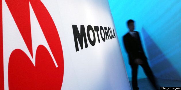 NEW YORK, NY - SEPTEMBER 05: A person walks by a Motorola sign at the launch of three new Motorola smartphones under its Razr brand that will become available for Verizon customers on September 5, 2012 in New York City. The new phones, the Droid Razr HD, the Razr M and the Razr Maxx HD, will all use Google's Android operating system. Motorola Mobility was acquired by Google in August of 2011. (Photo by Spencer Platt/Getty Images)