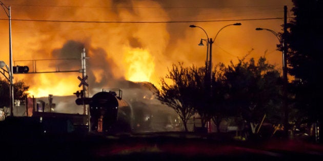 Firefighters douse blazes after a freight train loaded with oil derailed in Lac-Megantic in Canada's Quebec province on July 6, 2013, sparking explosions that engulfed about 30 buildings in fire. At least 80 people are missing after a driverless oil tanker train derailed and exploded in the small Canadian town of Lac-Megantic, destroying dozens of buildings, a firefighter back from the scene told AFP. AFP PHOTO / François Laplante-Delagrave (Photo credit should read François Laplante-Delagrave/AFP/Getty Images)