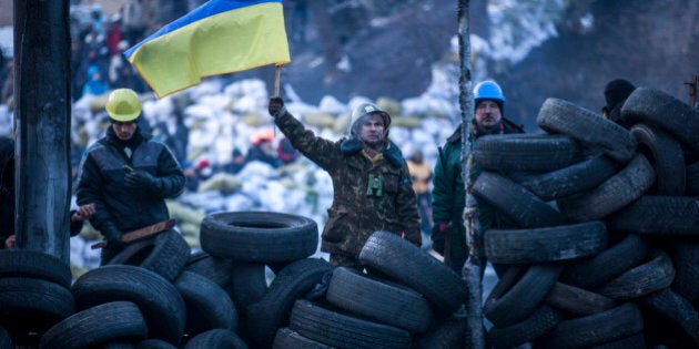 KIEV, UKRAINE - JANUARY 27: Anti-government protestors look towards police lines from a wall of tyres on Grushevskogo Street on January 27, 2014 in Kiev, Ukraine. Unrest is spreading across Ukraine, with activists taking over municipal buildings in several towns and cities including the east of the country where President Viktor Yanukovych has enjoyed strong support. (Photo by Rob Stothard/Getty Images)