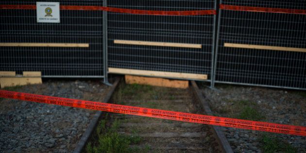 LAC-MEGANTIC, CANADA - JULY 14: Police tape marks the outside boundary of the 'red zone' crash site, on July 14, 2013 in Lac-Megantic, Quebec, Canada. A train derailed and exploded into a massive fire that flattened dozens of buildings in the town's historic district, leaving 60 people dead or missing in the early morning hours of July 6. (Photo by Ian Willms/Getty Images)