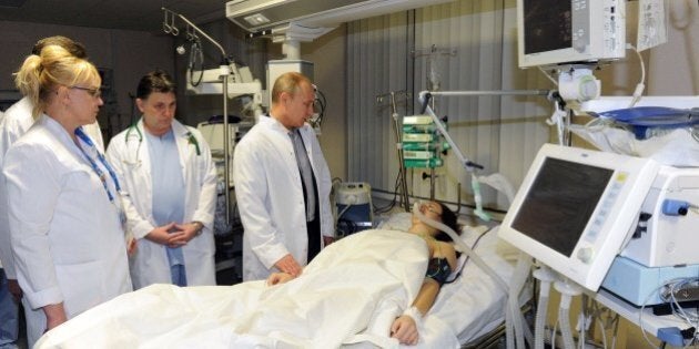 President Vladimir Putin (2nd R) visits Russian freestyle skier Maria Komissarova in a hospital in Sochi on February 15, 2014. 23-year-old Maria Komissarova sustained a broken back in a fall while training on the ski-cross course during the Sochi 2014 Winter Olympic Games . AFP PHOTO/ RIA-NOVOSTI/ POOL/ MIKHAIL KLIMENTYEV (Photo credit should read MIKHAIL KLIMENTYEV/AFP/Getty Images)