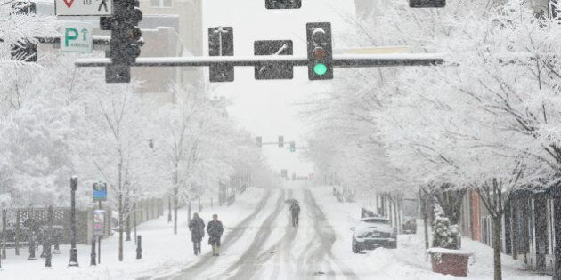 DURHAM, NC - FEBRUARY 13: People walk down Main Street as a heavy snow returns on February 13, 2014 in Durham, North Carolina. Snow and icy conditions shut down most roads and business throughout central North Carolina on Thursday. (Photo by Sara D. Davis/Getty Images)