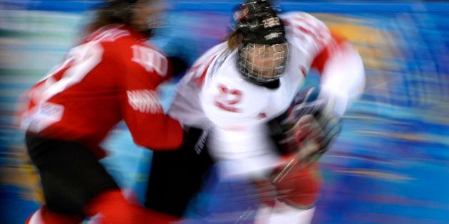 Canada's Hayley Wickenheiser (R) vies with Switzerland's Nicole Bullo during the Women's Ice Hockey semifinal match Canada vs Switzerland at the Shayba Arena during the Sochi Winter Olympics on February 17, 2014. Canada won 3-1. AFP PHOTO / JONATHAN NACKSTRAND (Photo credit should read JONATHAN NACKSTRAND/AFP/Getty Images)