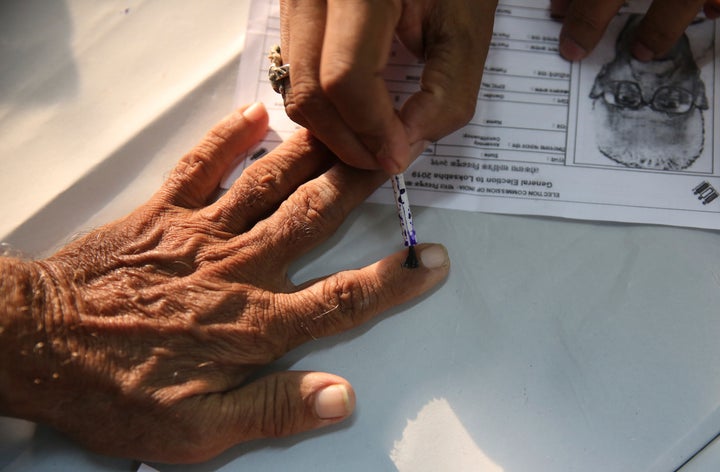 An elderly Indian citizen gets ink mark on his finger prior to voting at a polling center during the fourth phase of general elections in Mumbai, India, Monday, April 29, 2019. The voting over seven phases ends May 19, with counting scheduled for May 23.