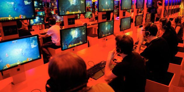 Besucher der Computerspiele-Messe Gamescom testen am Donnerstag (16.08.12) in Koeln am Stand des Herstellers Blizzard Entertainment das Spiel