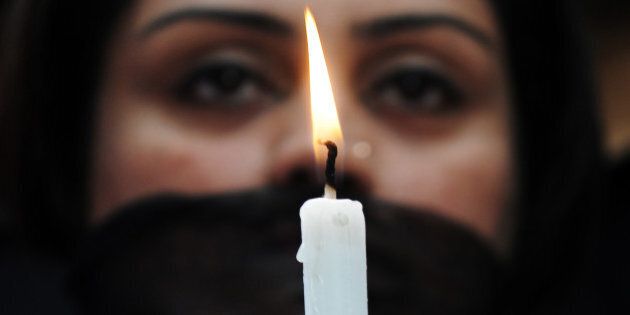 Indian members of a social organisation Our City Our Right holds a candle during a silent protest following the recent gang rape and murder of a 20-year-old college student in Barasat, in Kolkata on June 15, 2013. Activists and social groups in various parts of the state held rallies and protests following the incident. AFP PHOTO/ Dibyangshu SARKAR (Photo credit should read DIBYANGSHU SARKAR/AFP/Getty Images)
