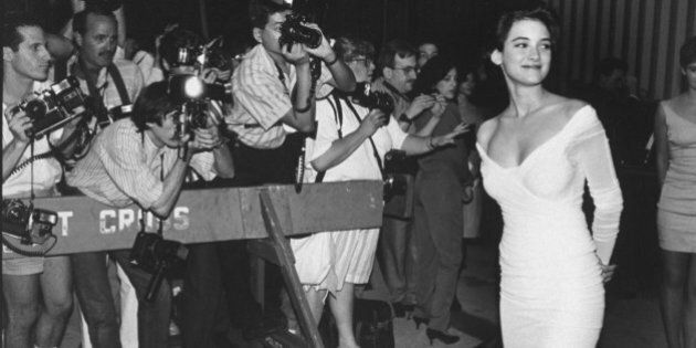 Actress Winona Ryder wearing low-cut tight white dress in front of photographers who are standing behind police barricades at premiere of film Great Balls of Fire. (Photo by Robin Platzer/Twin Images/Time Life Pictures/Getty Images)