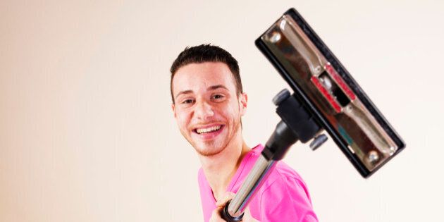 Happy young man with vacuum cleaner