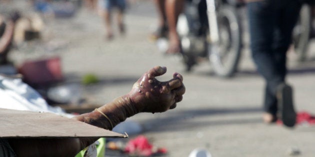 TACLOBAN, PHILIPPINES - NOVEMBER 10: (EDITORS NOTE: Image contains graphic content.) People killed during Typhoon Haiyan lay on the side of the road on November 10, 2013 in Tacloban City, Leyte, Philippines. Typhoon Haiyan, packing maximum sustained winds of 195 mph (315 kph), slammed into the southern Philippines and left a trail of destruction in multiple provinces, forcing hundreds of thousands to evacuate and making travel by air and land to hard-hit provinces difficult. Around 10,000 people are feared dead in the strongest typhoon to hit the Philippines this year. (Photo by Jeoffrey Maitem/Getty Images)