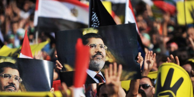 A protestor holds up a poster of ousted Egyptian President Mohamed Morsi during a demonstration condemning the recent deadly military crackdown on pro-Morsi protesters in Cairo on August 17, 2013, at New Mosque in Istanbul. Turkey branded the deadly crackdown in Egypt on protesters loyal to ousted president Mohamed Morsi today as 'unacceptable' and called on the international community to act immediately to halt the 'massacre'. AFP PHOTO/OZAN KOSE (Photo credit should read OZAN KOSE/AFP/Getty Images)