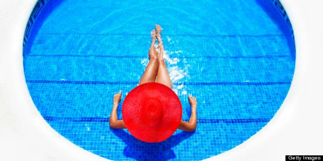 woman relaxing in resort swimming pool