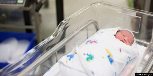 Newborn baby girl in hospital bassinet