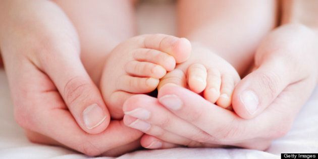 Mother holding baby's feet in hands, close-up