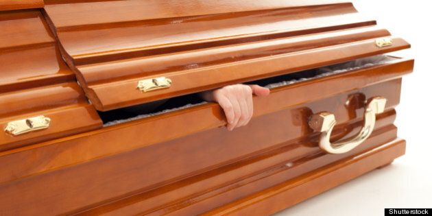 brown coffin with hand on the...