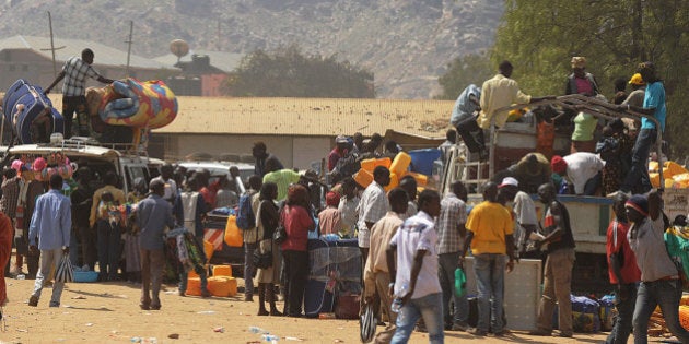 Residents of Juba with their belongings pile onto vehicles heading out of the city on December 21, 2013 where tension remains high fueling an exodus of both local and foreign residents from the south Sudanese capital. Brutal fighting in South Sudan has reopened deep-rooted ethnic divisions, forcing tens of thousands of terrified residents to seek shelter at UN bases or flee in fear of attacks. United Nations peacekeepers are currently sheltering over 35,000 civilians in various bases across the country, many belonging to the minority ethnic group in their respective areas. AFP PHOTO / TONY KARUMBA (Photo credit should read TONY KARUMBA/AFP/Getty Images)