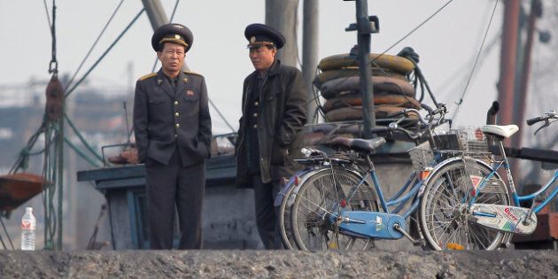 North Korean officials wait by the docks along the bank of the Yalu River in the North Korean town of Sinuiju across from the Chinese city of Dandong on April 4, 2013. North Korea appears to have moved a medium range missile to its east coast, South Korean Defence Minister Kim Kwan-Jin said, prompting fears of a strike against South Korea or Japan. CHINA OUT AFP PHOTO (Photo credit should read STR/AFP/Getty Images)